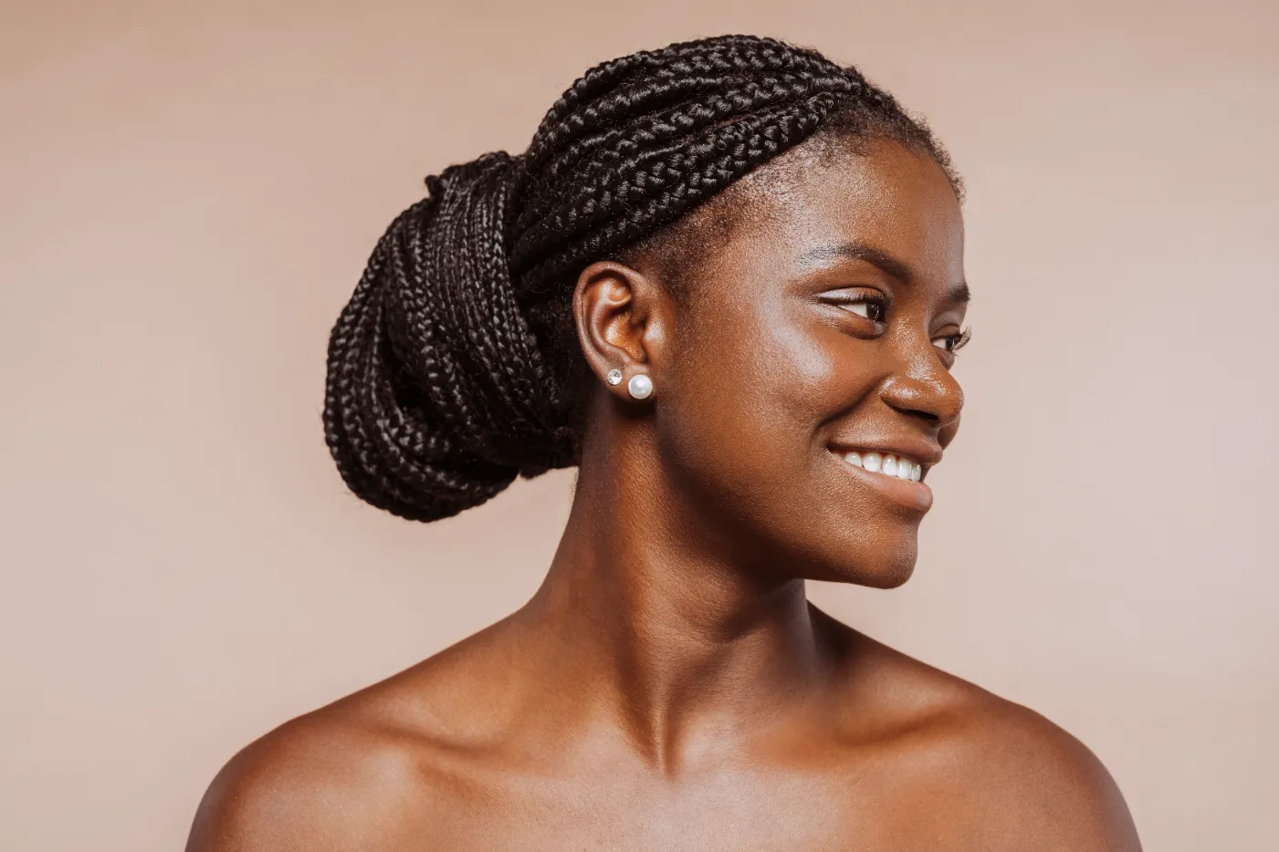 A portrait of a smiling african woman with long hair braids.