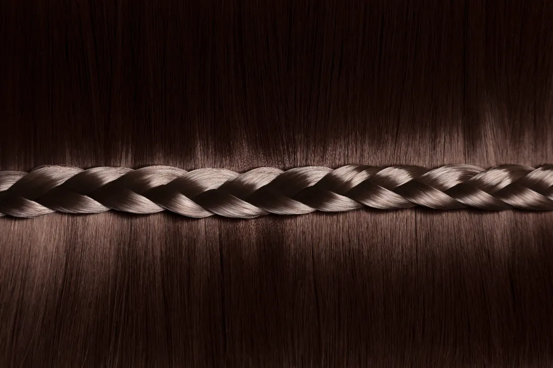 A closeup of glossy hair with braids pattern on the center.