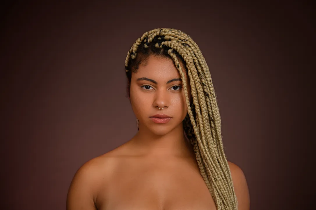 A portrait of a young multiracial woman with braids.